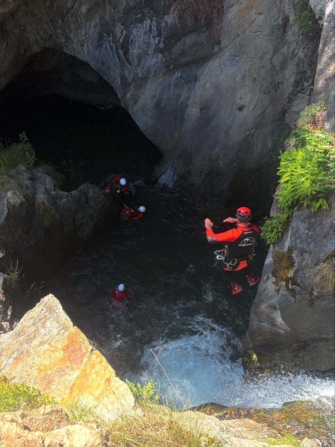 Kleine Gruppe schwimmt durch ein weites, milchig-türkises Becken in der Schlucht